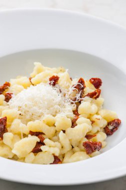 Kuru domatesli ve rendelenmiş peynirli halusky adında patates köftesi.