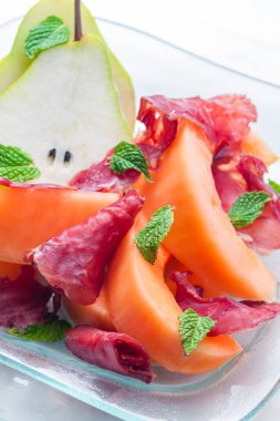 kavun kavunu ve armut, proscutto ve nane yapraklı.