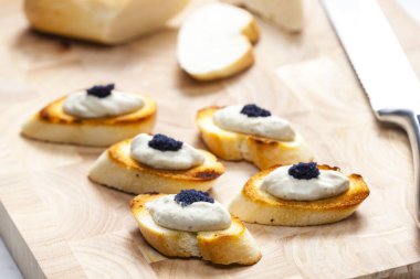 Kızarmış baget dilimlerine ançüez sürülmüş.