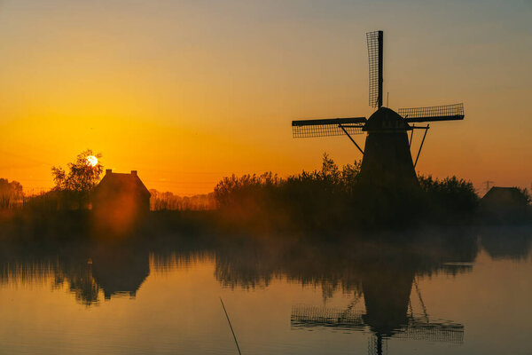 Traditional Dutch windmills with a colourful sky just before sunrise in Kinderdijk, The Netherlands