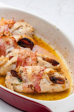 Domuz pastırmasında kurutulmuş domatesle doldurulmuş tavuk dürümü.