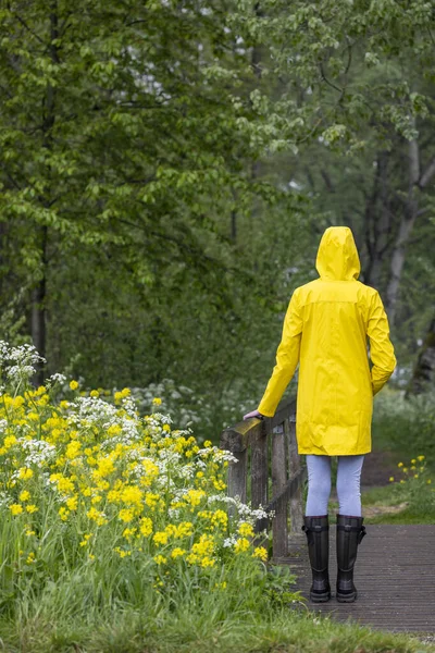 Junge Frau Mit Gelbem Regenmantel Und Gummistiefeln Der Frühlingsnatur — Stockfoto