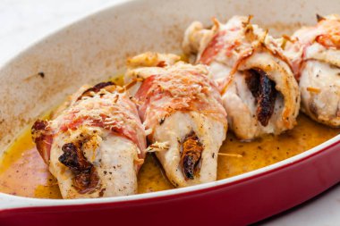 Domuz pastırmasında kurutulmuş domatesle doldurulmuş tavuk dürümü.