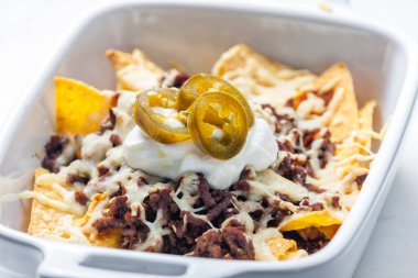 Kıyılmış et ve peynirli cips. Krem şanti ve jalapeno ile servis ediliyor.