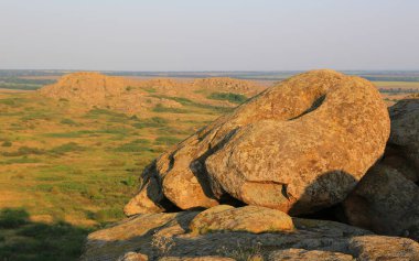 Bozkırda, sıcak akşam ışığında eski taşlarla kaplı bir manzara. Ukrayna 'dan al.