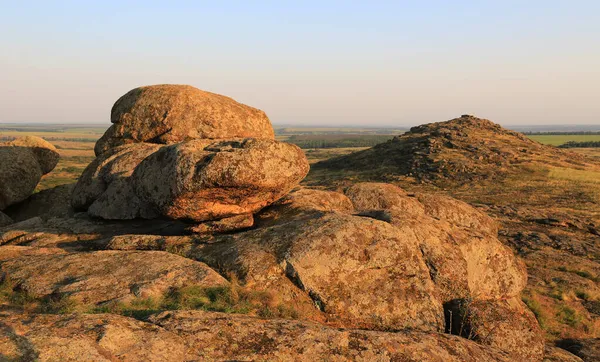 Bozkırda, sıcak ışıkta eski taşlarla kaplı bir manzara. Ukrayna 'daki Nazarivka köyüne yakın bir yere götür.