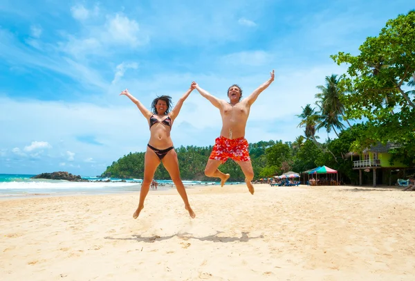 Paar springen op een strand — Stockfoto