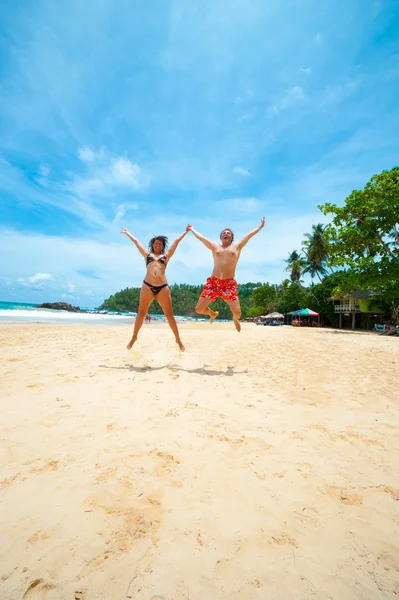 Paar springen op een strand — Stockfoto