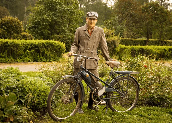 Young man posing with retro motorbike in the park. — Stock Photo, Image