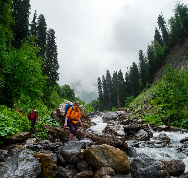 Hikers group cross the mountain river — Stock Photo, Image
