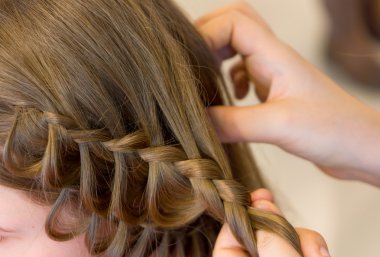 Hairdresser makes braids clipart
