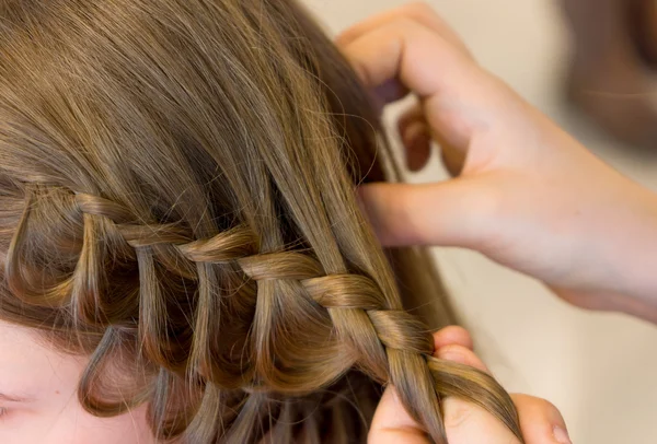 Friseur macht Zöpfe — Stockfoto