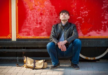Young man sits and thinks