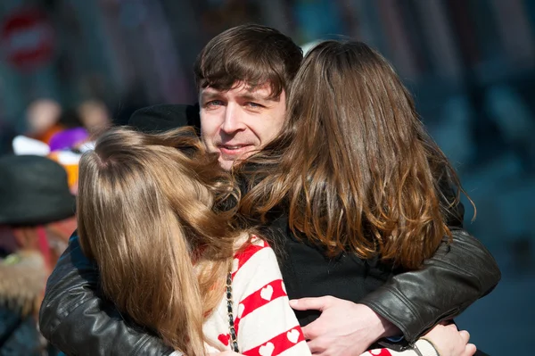 Giovane uomo che abbraccia due ragazze per strada . — Foto Stock