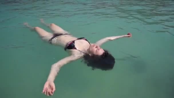 Jovem mulher relaxar como uma estrela do mar no oceano — Vídeo de Stock