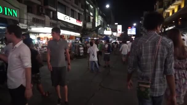 観光客は、有名なバックパッカーズ先カオ サン通りに沿って歩く — ストック動画