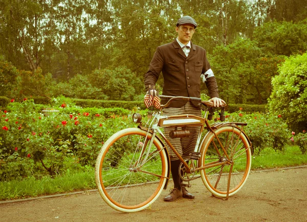 Мужчина позирует с ретро-велосипедом в парке — стоковое фото