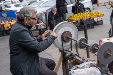 Bıçak öğütücü pazarda çalışıyor