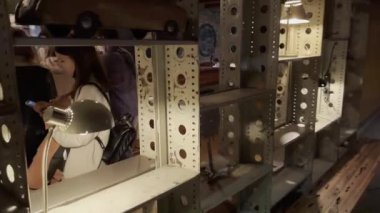 Loş bardaki rafların arkasındaki insanlar.