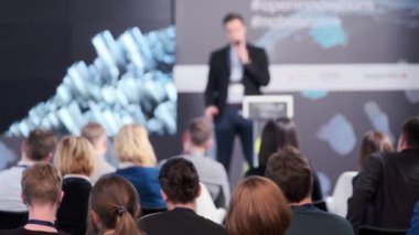 İş semineri sırasında izleyiciler sunumu izliyor