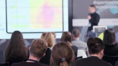 İş semineri sırasında izleyiciler sunumu izliyor