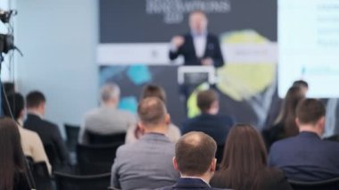 Oditoryumdaki işadamını dinleyen insanlar