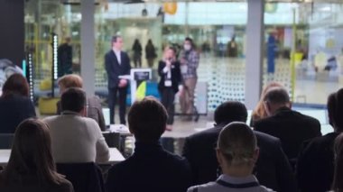 İnsanlar iş konferansı sırasında modern salonda toplanıyorlar.