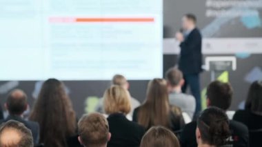 İş semineri sırasında izleyiciler sunumu izliyor