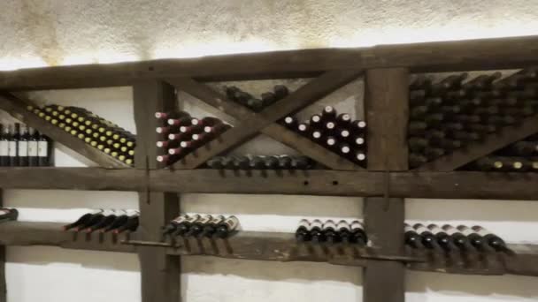 Бутылки вина на деревянных полках — стоковое видео