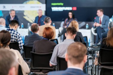 Konferans odasında oturan insanlar