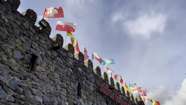 Kale duvarında dalgalanan farklı bayraklar — Stok video