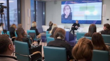 Konferans salonunda insanlar çevrimiçi sunum izliyor