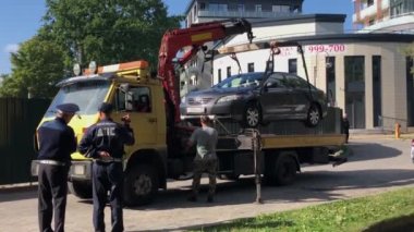 Trafik memurları arabayı yıkıcıyla hareket ettiriyor.