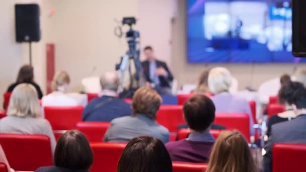 Participantes del seminario empresarial sentados cerca de la cámara durante el discurso — Vídeos de Stock