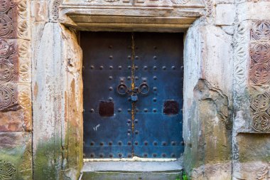 Metal kapıda asma kilit olan zincir.