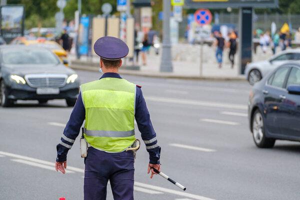 Офицер дорожного движения стоит у дороги