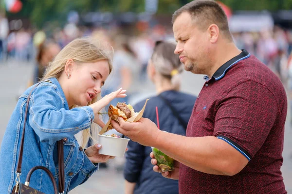 Adult couple sharing food on street — Stock Photo, Image