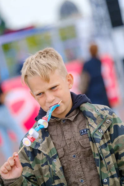 Boy eating jelly skewer on street - Stok İmaj