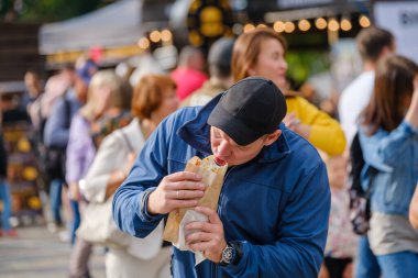 Sokakta fast food yiyen bir adam