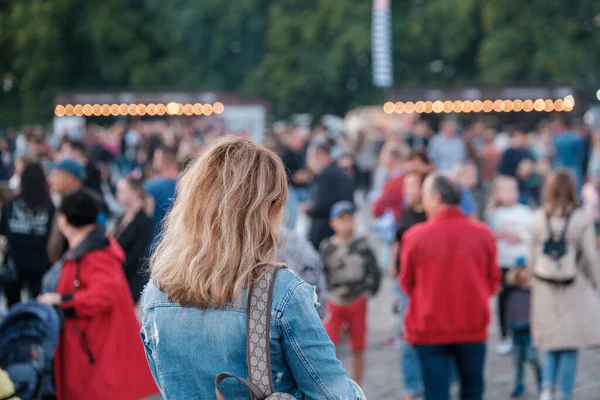 Woman walking in crowded park — Stockfoto