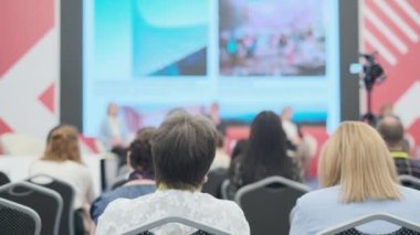 Büyük ekranda sunumu izleyen bir grup insan