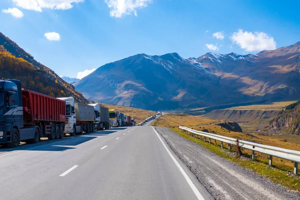 Vrachtwagens langs de weg in de buurt van bergen — Stockfoto