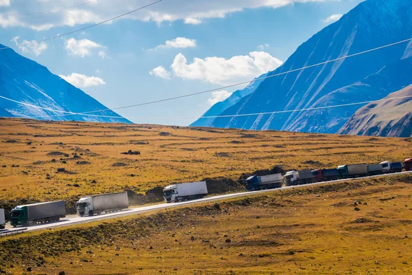 Trucks driving in valley near mountains