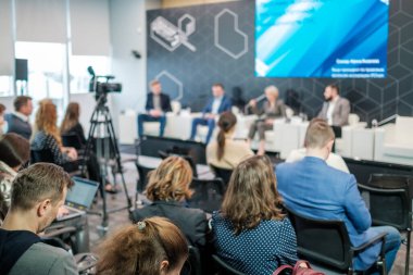 İş konferansına katılırken konuşmaları dinleyen tanınmayan katılımcıların bakışını hafifçe eğ