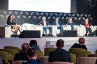 İş konferansına katılırken konuşmaları dinleyen tanınmayan katılımcıların bakışını hafifçe eğ