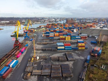 Kaliningrad, Russia - October 12,2021: Drone view of ships docked in commercial harbor with many cargo containers on gray day
