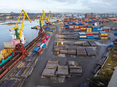 Kaliningrad, Russia - October 12,2021: Drone view of ships docked in commercial harbor with many cargo containers on gray day