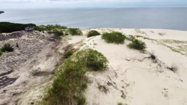 Bulutlu mavi gökyüzüne karşı Baltık Denizi yakınlarındaki Kurak Curonian Spit 'in resimli drone görüntüsü