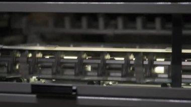 Matbaanın atölyesinde parlak lambalar üreten yakın endüstriyel makine.