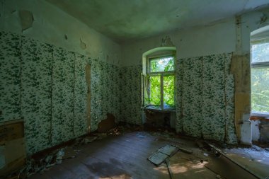 Çökmüş duvarları olan loş boş bir odanın içi ve terk edilmiş bir binanın içinde, yaz günü pencere açıldı.